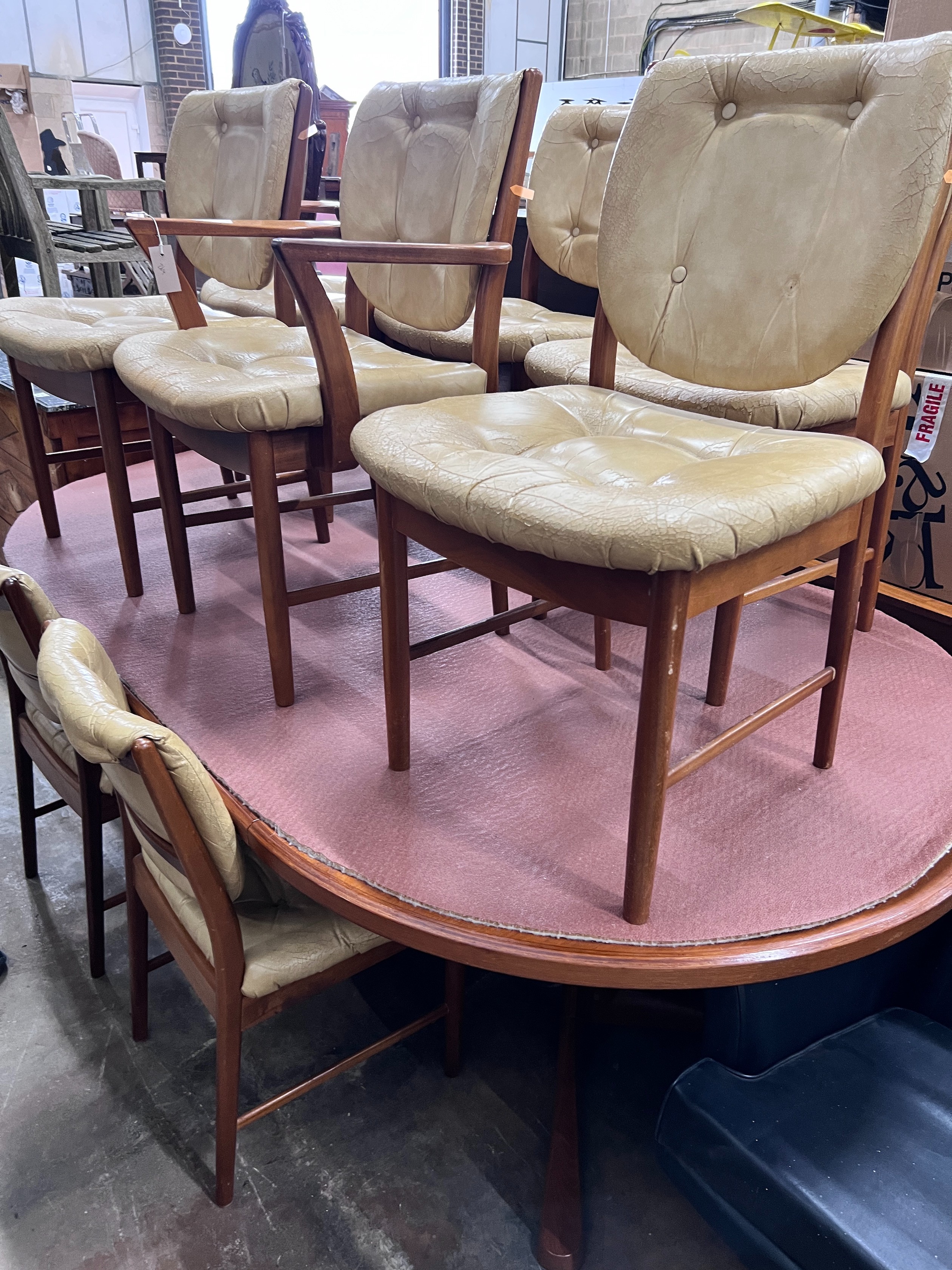 A mid century McIntosh of Kirkaldy golden teak dining suite comprising extending dining table, length 230cm, depth 125cm, height 72cm, eight chairs and sideboard *Please note the sale commences at 9am.